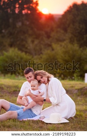 Family portrait mother father and baby on lavender field having fun together. Happy couple with child