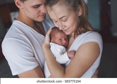 Family Portrait: Mother, Father And Newborn Baby.