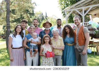 Family portrait at outdoor summer garden party. Family and friends standing, posing for a group photo. Multigenerational family. - Powered by Shutterstock