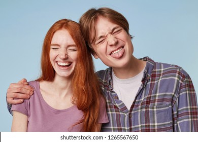 Family Portrait Of Young Cheerful Funny Joyful Couple, Play Ape, Smile And Feels Happy. Indoor Shot Of Young Male With Braces Hugs His Girlfriend Wich Smiles Broadly