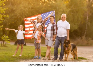 Family Posing Outdoors With American Flag - Powered by Shutterstock