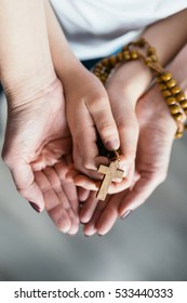 Family Prayer. Mother And Child Hands With Wooden Rosary