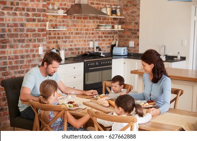 Family Praying Before Eating Meal In Kitchen Together - Powered by Shutterstock