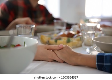 Family Praying Before Meal At Home