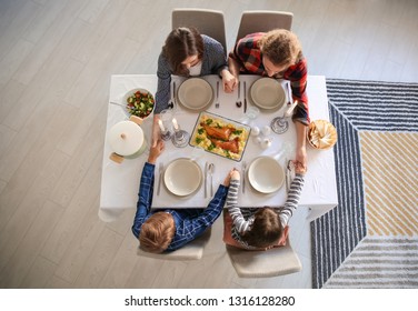 Family Praying Before Meal At Home