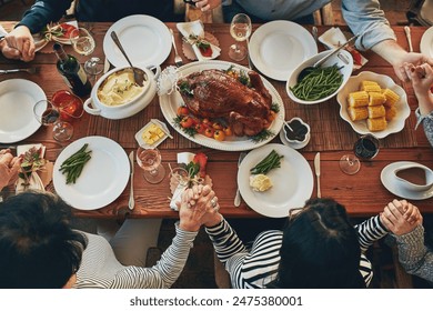 Family, praying and grace for thanksgiving, dinner and celebration outdoor with food, wine or love. Group of people, faith and together at table for holiday, above and gratitude with drink or turkey - Powered by Shutterstock