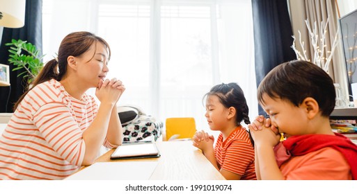 Family Praying And Worship To GOD With Church Online Sunday Service.Live Church With Bible.Mother Kid Sibling Praying On Holy Bible Study At Home.Lockdown Worship.Christian Faith Hope.Online Church.