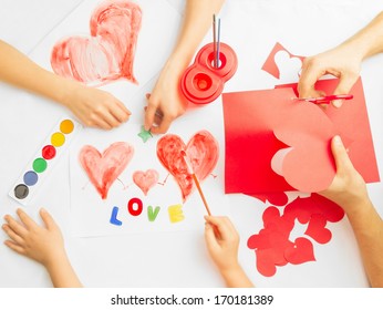 Family prepare for Valentine's Day. Paintings and origami of heart. Concept of family. Point of view shot