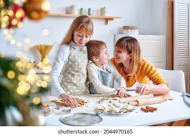 Family Is Preparing Holiday Food. Mother, Daughter And Son Is Cooking Christmas Cookies. Mom's Nose Is Smeared With Flour. Funny Christmas Time And Holidays.