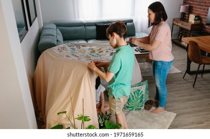 Family Preparing A Homemade Tent To Camping At Home