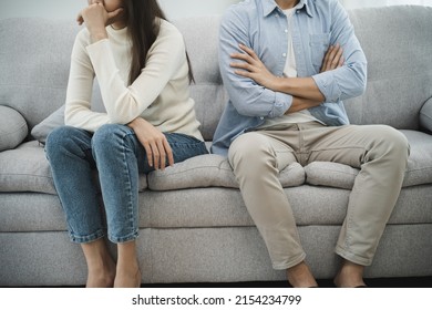 Family problems, Asian women cover her face and sit separately from husband feel disappointed after quarrels at home.