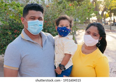 Family With Protective Mask Holding Baby In Park