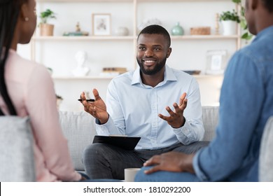 Family Psychotherapy. Friendly Black Therapist Consulting African American Couple At His Office, Selective Focus On Counselor