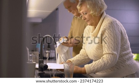 A family quickly washing dishes after a meal together, everyday life routine, active seniors