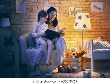 Family Reading Bedtime. Pretty Young Mother Reading A Book To Her Daughter. Happy Time At Home.