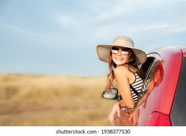 Family ready for the travel on summer vacation. Cute happy smiling little girl child is sitting in the red car with luggage and bags outdoors. Travel trip concept. 