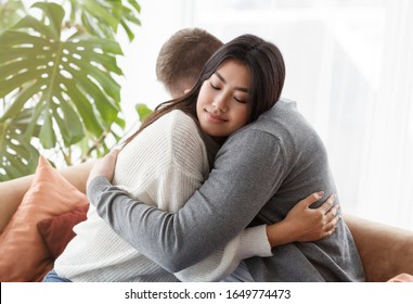 Family Reconciliation. Loving Spouses Hugging After Effective Couple Therapy Sitting In Psychologist's Office