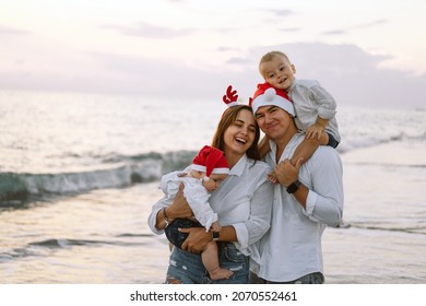 Family In A Red Santa Hat Walk On The Beach. Family Celebrate Christmas And New Year At Tropics. New Year Concept.