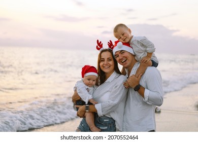 Family In A Red Santa Hat Walk On The Beach. Family Celebrate Christmas And New Year At Tropics. New Year Concept.