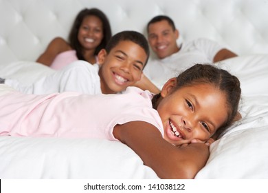 Family Relaxing In Bed Together - Powered by Shutterstock