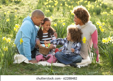 Family Relaxing In Field Of Spring Daffodils