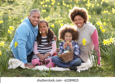 Family Relaxing In Field Of Spring Daffodils