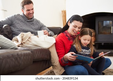 Family Relaxing Indoors And Reading Book