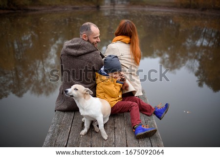 Family Relaxing Indoors And Stroking Pet Dog