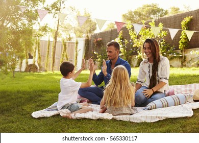 Family Relaxing On Blanket In Garden