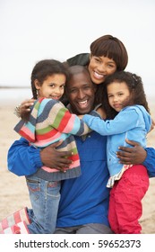 Family Relaxing On Winter Beach Break