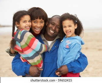 Family Relaxing On Winter Beach Break