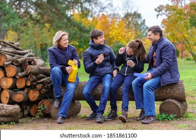 family relaxing outdoor in autumn city park, happy people together, parents and children, they drink tea, talking and smiling, beautiful nature