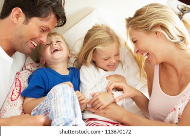 Family Relaxing Together In Bed