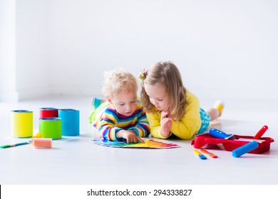 Family Remodeling House. Home Remodel And Renovation. Kids Painting Walls With Colorful Brush And Roller. Children Paint Wall. Choice Of Bright Color On Sample Palette For Child Nursery Or Kid Room.