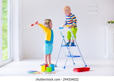 Family Remodeling House. Home Remodel And Renovation. Kids Painting Walls With Colorful Brush And Roller. Children Paint Wall. Choice Of Bright Color On Sample Palette For Child Nursery Or Kid Room.