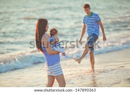Family resting on the sea during sunset