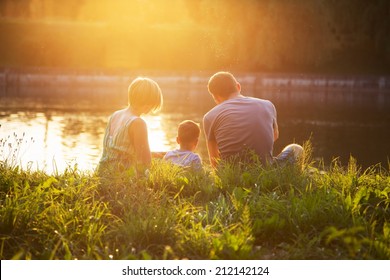 Family Resting At Sunset In The Park