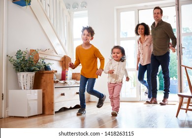 Family Returning Home After Trip Out With Excited Children Running Ahead