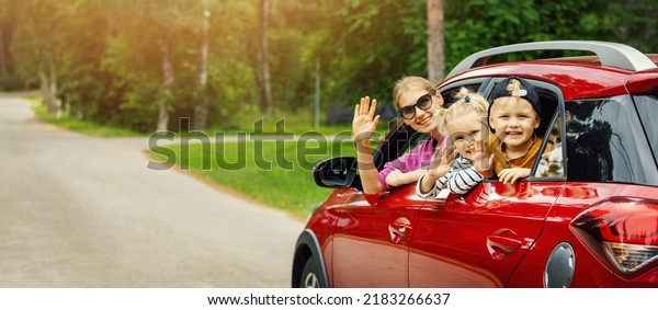 family road trip. mother with
children waving out of the car window. banner with copy
space
