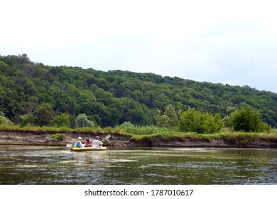 Family Rowing In A Yellow Kayak In Summer Along The Trees At The Bank Of Seversky Donets River.