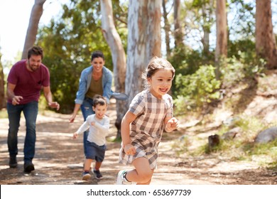 Family Running Along Path Through Forest Together