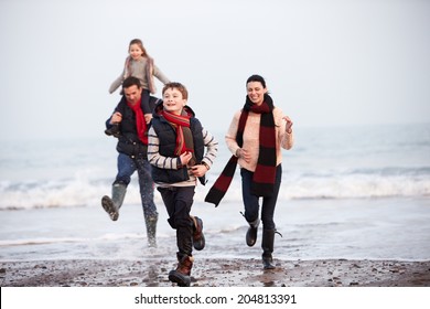 Family Running Along Winter Beach