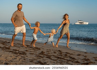 Family Running and Holding Hands on the Beach by the Ocean at Su