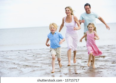 Family Running On Beach Smiling