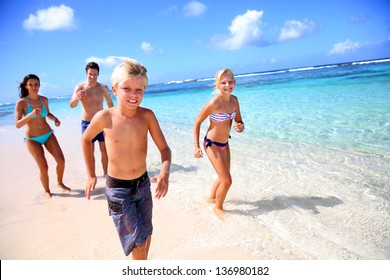 Family Running On A Paradisaical Beach