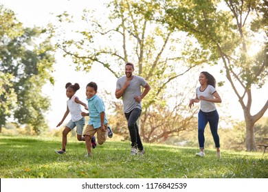 Family Running Through Park Together