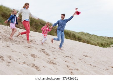 Family Running Through Sand Dunes Together