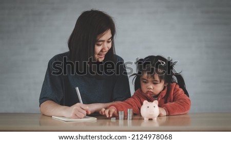 Family Saving money. Asian Woman and daughter plan to spend the future in earnest, finance and saving, family and financial concept.