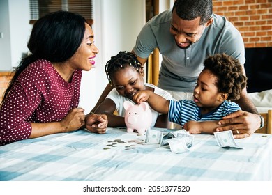 Family Saving Money In A Piggy Bank