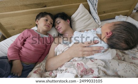 Similar – Relaxed mother and sons playing over the bed